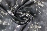 Swirled swatch Posing Skeletons fabric (black and grey marbled/distressed look fabric with tossed skeletons in various poses)