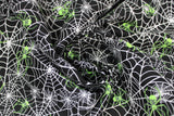 Swirled swatch Spiderwebs fabric (black fabric with tossed white spiderwebs allover with lime green spiders tossed within)