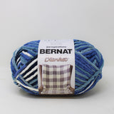 Ball of Bernat Blanket yarn in shade Faded Blues (bright blue, medium pale blue, black and white)