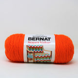 A ball of Bernat Super Value yarn in shade Carrot (bright orange)