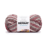 A ball of Bernat Symphony yarn in shade Pomegranate Punch (whites, browns and greys with pale reds in twisted shades)