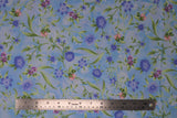 Flat swatch Lilac fabric (white and sky blue marbled look fabric with loosely tossed floral and stems, greenery allover in green, white, blue, purple and pink)
