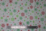 Flat swatch snowflakes fabric (white fabric with tossed red and green snowflakes allover in various shapes and styles, pale blue star shines in background)