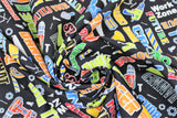 Swirled swatch Work Zone fabric (black fabric with tossed cartoon style tools in full colour with work related text allover in multi directions "Hard Hat" "Caution" "Do Not Enter" etc. all in bright colours)