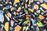 Swirled swatch Tools Toss fabric (black fabric with tossed cartoon style tools allover in bright colours: drills, measuring tapes, pliers, screw drivers, screws, nuts, bolts, hard hats, pilons, etc.)