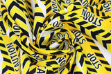 Swirled swatch Caution Stop fabric (white fabric with wrapped look caution tape in yellow with black markings and "Stop" "Caution" text)