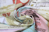 Swirled swatch Paris themed upholstery fabric (collage of French labels/stamps/seals in various shapes and colours)