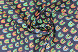Swirled swatch printed fabric from the Chili Smiles line in black rainbows (black fabric with small tiled colourful rainbow arches)