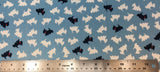 Flat swatch black and white scotty dogs fabric in blue (pale medium blue fabric with tossed scotty dog silhouettes in white, occasional black with red bandana) 