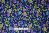 Flat swatch navy layered fabric (navy fabric with tossed layered wildflower floral in yellow, blue, purple, orange floral heads and green stems/leaves)