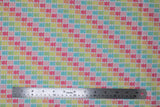 Flat swatch bright gummy bears fabric (white fabric with gummy bears in rows allover coloured in bright rainbow shades forming diagonal colour stripes)