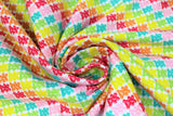 Swirled swatch Gummy Bears fabric (white fabric with packed gummy bear candies in various colours creating diagonal stripes in yellow, green, blue, pink, red, orange)
