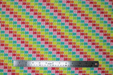 Flat swatch Gummy Bears fabric (white fabric with packed gummy bear candies in various colours creating diagonal stripes in yellow, green, blue, pink, red, orange)