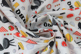 Swirled swatch king of the grill fabric (off white fabric with tossed bbq related emblems: black bbqs, hamburgers, ketchup, mustard, onions, mushrooms, skewers, hot dogs, etc.)