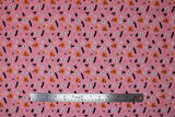 Flat swatch Spooky Season fabric (pink fabric with tossed halloween related emblems allover: with hats, bats, potions, jack o lanterns, etc.)