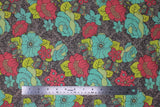 Flat swatch Aphrodite's Garden fabric (medium grey fabric with dark grey swirly floral pattern background, and large tossed drawn look floral allover in various styles in yellow, blue and pink with tossed decorative butterflies in same colourway)