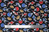 Flat swatch of football printed fabric on black (black fabric with tossed red and blue football helmets, brown footballs, small cartoon blue and red football players in various tackle/run positions)