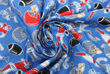 Swirled swatch of football printed fabric on blue (medium blue fabric with tossed red and blue football helmets, brown footballs, small cartoon blue and red football players in various tackle/run positions)