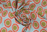 Swirled swatch Gerbers fabric (white fabric with tiny teal blue dots background, tossed orange watercolour paint look daisies with white spotted brown centers)