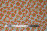 Flat swatch Gerbers fabric (white fabric with tiny teal blue dots background, tossed orange watercolour paint look daisies with white spotted brown centers)