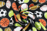 Swirled swatch of assorted sports balls fabric on black (black fabric with small tossed soccer, tennis, baseball, football, basketball)