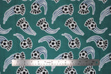 Flat soccer ball printed fabric swatch in green (medium pale green fabric with black/white soccer balls with sport swoosh lines in blue and "GOAL!" text in black)