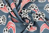 Swirled soccer ball printed fabric swatch in grey (medium grey fabric with black/white soccer balls with sport swoosh lines in blue and "GOAL!" text in black)