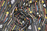 Swirled swatch licensed DC Comics printed fabric in Retro Action (superman logo and zoom cartoon on black)