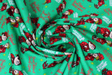 Swirled swatch jingle jangle fabric (green fabric with white "Jingle Jangle" text, red "The Year Without Santa Claus" text, tossed red and yellow tiny stars, tossed red elf characters allover)