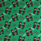 Square swatch jingle jangle fabric (green fabric with white "Jingle Jangle" text, red "The Year Without Santa Claus" text, tossed red and yellow tiny stars, tossed red elf characters allover)