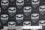 Flat swatch Batman I am Shadows fabric (black fabric with black and grey batman character behind glowing window with black bat above and grey "I AM THE SHADOWS" text)