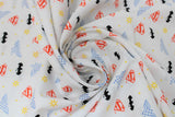 Swirled swatch licensed DC Comics printed fabric in Retro Logos (small assorted DC heros logos on white)