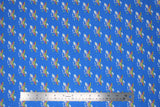 Flat swatch licensed DC Comics printed fabric in Wonder Woman Cloud (yellow and pink W logo with small clouds on blue)
