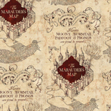 Swatch of Harry Potter themed quilting cotton fabric.  Alternating motifs in offset rows over a parchment coloured and textured background.  One motif is a line drawing of four walls enclosing a square, which is filled with deep red and the words "The Marauder's Map". Tightly written latin text in a large abstract blob below. The other motif features an ornately curled banner reading "Itinerarium Maraudentium", over the words "Messrs. MOONY, WORMTAIL, PADFOOT & PRONGS are proud to present".