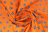 Swirled swatch deathly hallows glow fabric (bright orange fabric with small tossed black deathly hallows symbol (triangle with circle and vertical line within) outlined in white tossed allover)
