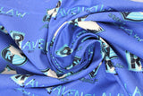 Swirled swatch licensed Harry Potter printed fabric in Ravenclaw Traits Scatter (crest and text tiled on blue)