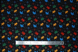Flat swatch snowflake houses fabric (black fabric with deconstructed christmas sweater look design, tossed digitized look snowflakes and HP house emblems in yellow, blue, green and red)