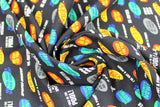 Swirled swatch Catchphrases fabric (black fabric with show logo and popular phrases from the show in different fonts and red, yellow, green, blue, white and grey colours)