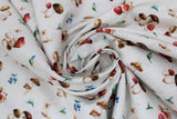 Swirled swatch baby themed fabric in mushroom toss (white/faint brown wood grain fabric with tiny white/brown/red mushrooms tossed with blue flowers and green leaves)
