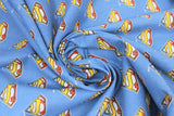 Swirled swatch licensed DC Comics printed fabric in Retro Logo (tiled multi-coloured superman logo on blue)