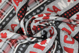 Swirled swatch gray multi stripe 1 fabric ("Canada" text stripes in red and white lettering on grey background, black/red buffalo stripes, grey with faint polka dots and red leaves stripe, red plaid stripe, grey leaves on dark grey stripe, repeated pattern)