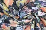 Swirled swatch autumn fabric (black fabric with scattered layered leaves in white and orange, blue, green, yellow, purple shades)