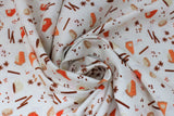 Swirled swatch Autumn Treats fabric (white fabric with tossed fall themed coffee treats emblems tossed allover in full colour: lattes, coffee, cinnamon sticks, coffee beans, etc.)