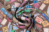 Swirled swatch Brown Signs fabric (brown woodgrain look collaged fabric with tossed construction signs allover in various styles/colours "TOOLS" "WORKSHOP" "WET PAINT" etc)