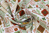 Swirled swatch Words fabric (white fabric with multi directional text allover in red and green with gold metallic accents and tossed christmas themed badges, text is: "Holy Night" "Rejoice" "Noel" etc)