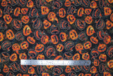 Flat swatch Pumpkins fabric (black fabric with swirly designs in background and tossed jack o lantern pumpkins and outlines allover)