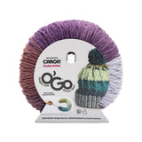 Caron Colorama round shaped yarn with label in colourway Concord Crush (burgundy purple, plum purple, pale purple, medium purple, deep purple)