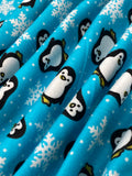 Swirled swatch winter themed flannel in Penguins (cartoon penguins and snowflakes on light blue)
