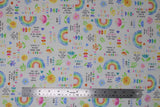 Flat swatch sweet dreams fabric (white fabric with small tossed colourful emblems allover: rainbows, hearts, flowers, "Sweet dreams" text, "Learn and grow" text, etc.)