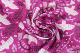 Swirled swatch of Marabella fabric in summer plum (pale purple/magenta fabric with tossed emblems allover in white and dark purple: doves, assorted floral and greenery)